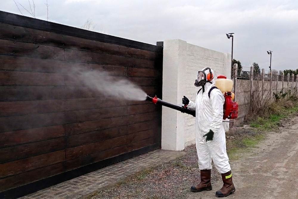 Fumigación perimetral de una propiedad: técnico de Groupest aplicando nebulización en el acceso exterior con equipo motorizado