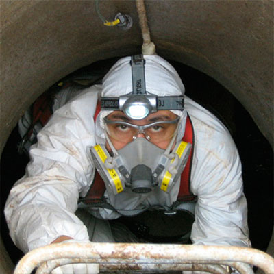 Técnico de Groupest ingresando a un estanque de agua con equipo de protección completo
