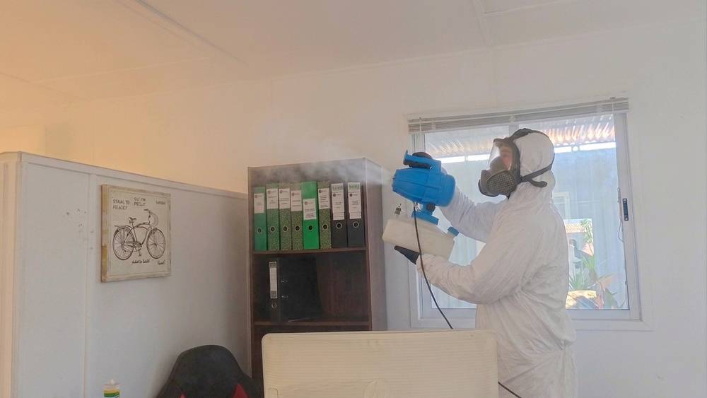 Sanitización ambiental de oficina en Santiago: técnico certificado de Groupest aplicando nebulización con productos de Registro ISP